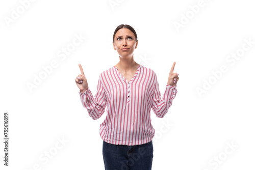 young brunette office worker woman dressed in a shirt points with her hands to the space for advertising