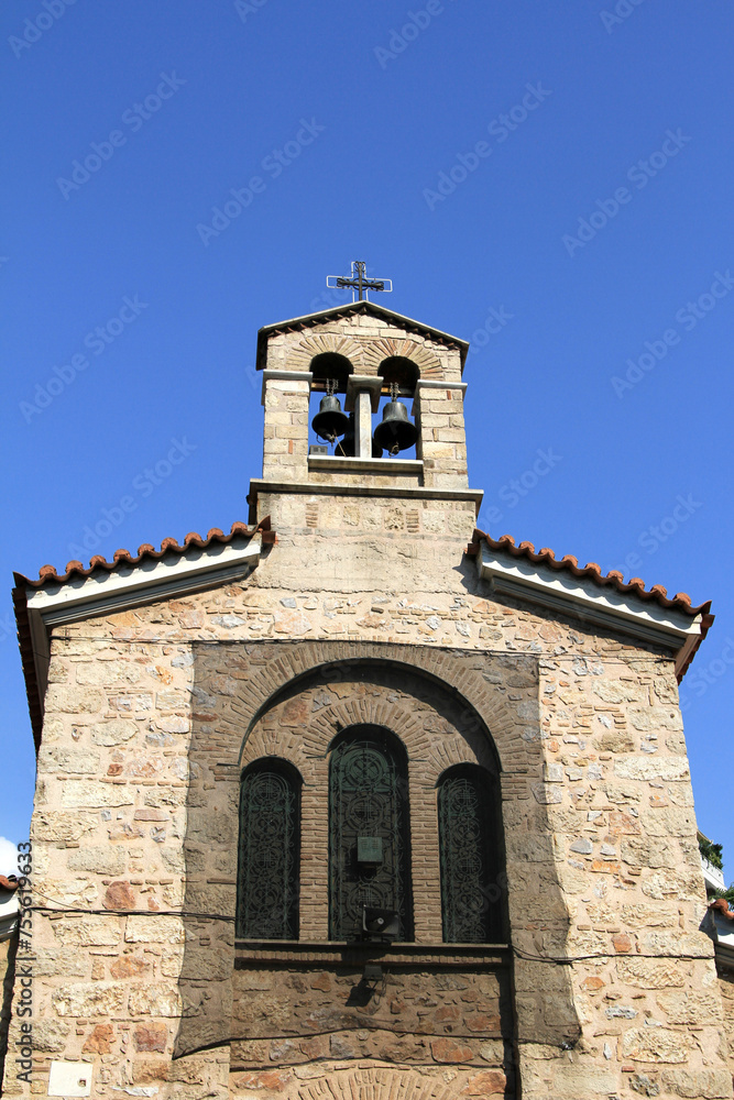 Vertical shot of an ancient church with a tower and two bells atop in Athens, Greece