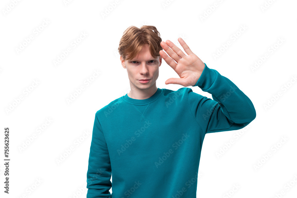 portrait of a handsome young caucasian student guy with red hair dressed in a blue pullover portrait of a handsome young caucasian student guy with red hair dressed in a blue pullover