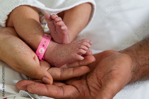 New born baby feet on the hands of a happy dad 