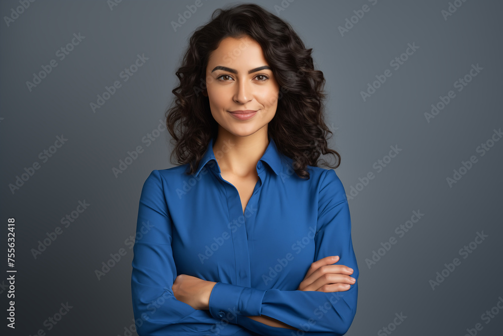Happy young smiling confident professional business woman wearing blue shirt, pretty stylish female executive looking at camera, standing arms crossed isolated at gray background Happy young smiling confident professional business woman wearing blue shirt, pretty stylish female executive looking at camera, standing arms crossed isolated at gray background