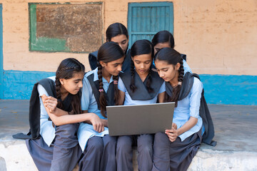 Group of rural indian school girls students studying using laptop or learning computer- Digital education in india. Wireless technology. Knowledge.