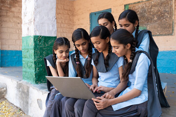 Group of rural indian school girls students using laptop or learning computer- Digital education in india. Wireless technology. Knowledge.
