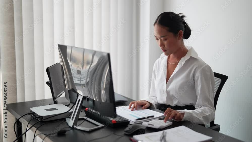 Asian businesswoman working in her office, using a calculator to estimate the budget for her project. Managing finances efficiently for successful project execution Asian businesswoman working in her office, using a calculator to estimate the budget for her project. Managing finances efficiently for successful project execution