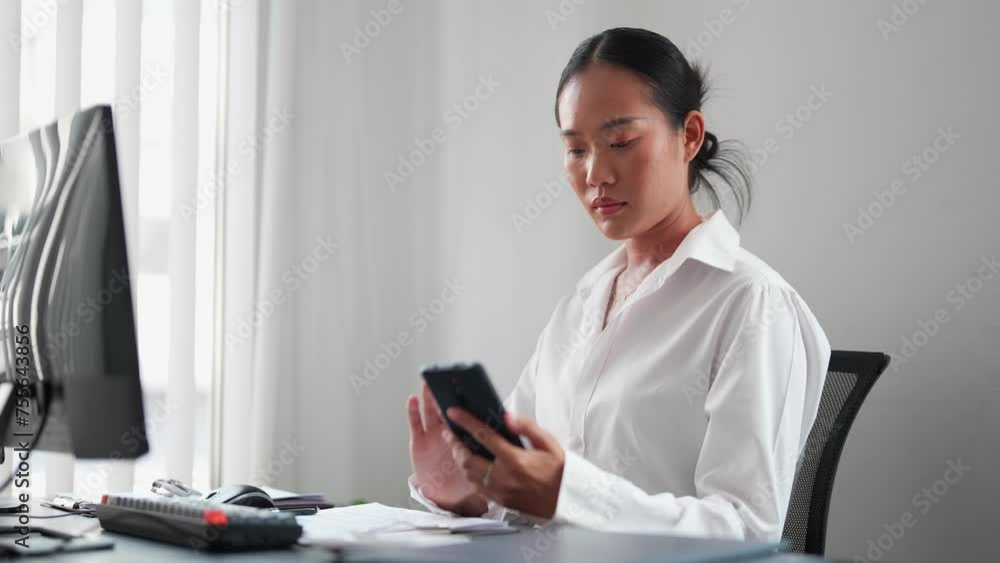 Asian businesswoman using a smartphone to stay informed with the latest news at her office. Keeping up-to-date for informed decision-making Asian businesswoman using a smartphone to stay informed with the latest news at her office. Keeping up-to-date for informed decision-making