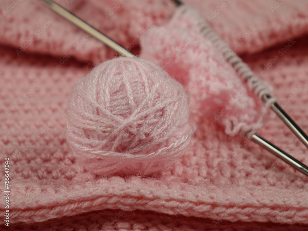 Knitted items from pink yarn and a set for hand knitting on a pink background
Knitted items from pink yarn and a set for hand knitting on a pink background