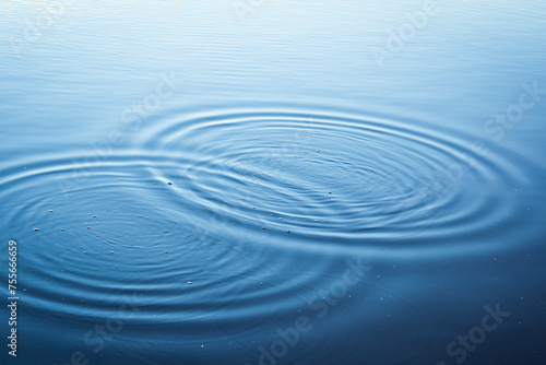 Round droplets of water over circles on the lake. Water drop, whirl and splash.Phone and laptop wallpaper. Close Up water rings affect the surface.