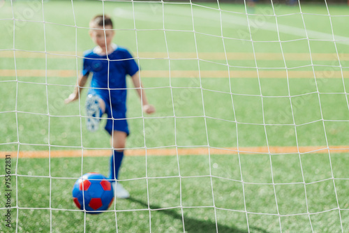 Young Soccer Player Scores a Goal, Focus on Ball photo