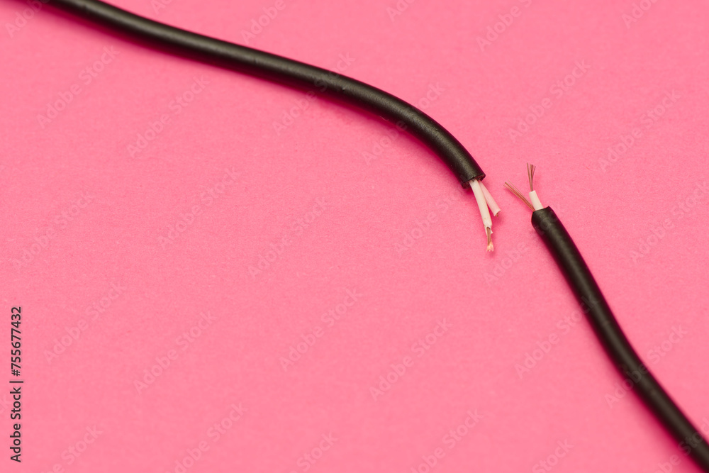 Two ends of a torn cable with a copper core, on a pink background. Broken cable requiring repair. Disconnection concept Two ends of a torn cable with a copper core, on a pink background. Broken cable requiring repair. Disconnection concept