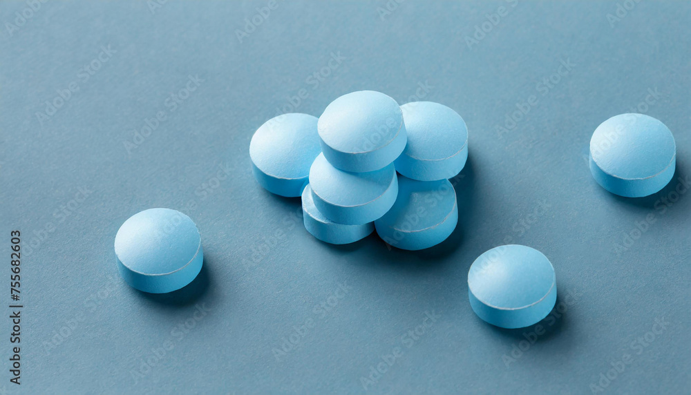 Blue round pills on top of light surface. Pharmaceutical drug. Medical treatment. Blue round pills on top of light surface. Pharmaceutical drug. Medical treatment.
