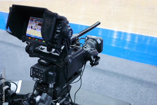 Professional camera with microphone at basketball game in modern stadium