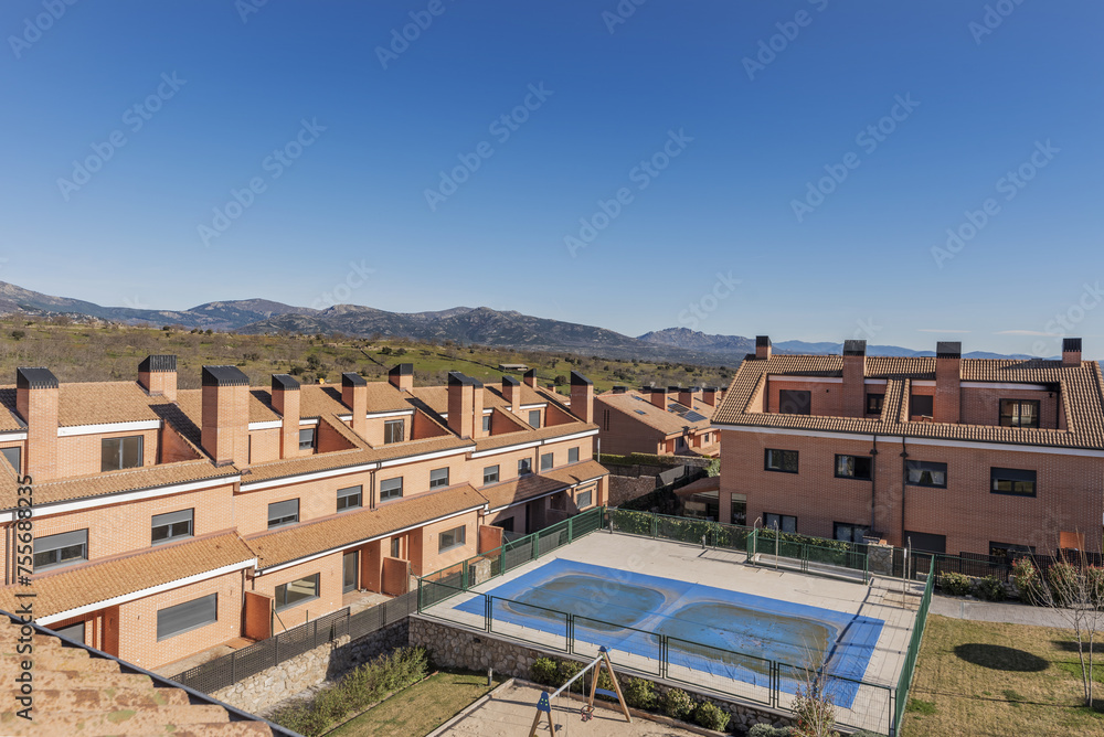 An urbanization of semi-detached single-family homes with a swimming pool in the common areas An urbanization of semi-detached single-family homes with a swimming pool in the common areas