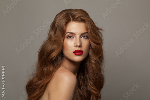 Elegant stylish woman fashion model with long healthy shiny wavy hair posing on white background, fashion beauty studio portrait