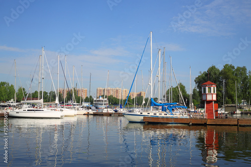 Pier, many yachts and boats on river in town on sunny summer day photo