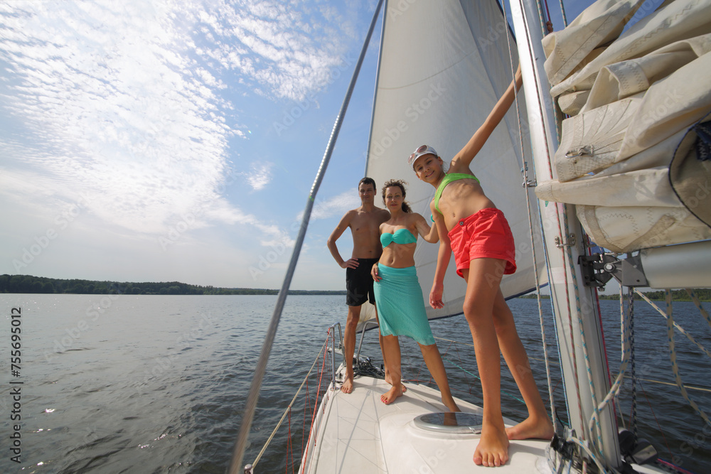 Father, mother and happy daughter sail on white yacht on river at summer sunny day Father, mother and happy daughter sail on white yacht on river at summer sunny day