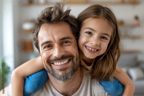 Happy strong dad piggybacking cheerful kid girl with flying open arms, looking at camera, smiling for portrait, carrying playful daughter on back in living room, promoting family leisure, fatherhood