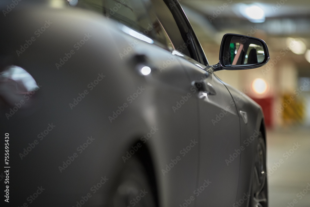 Fototapeta premium Right side of modern car at underground parking, focus on rear view mirror