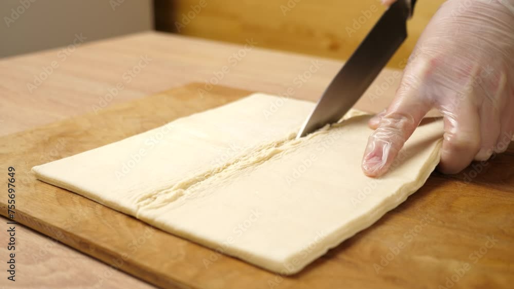 Cut the puff pastry in half with a knife. Making puff pastry pies. Cut the puff pastry in half with a knife. Making puff pastry pies.