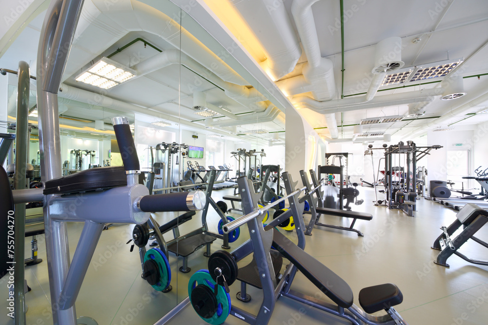 Fototapeta premium Empty modern gym with new shiny fitness equipment, big mirror for sport training