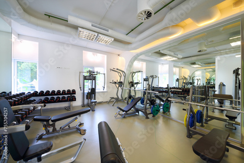 Empty modern gym with new shiny fitness equipment, dumbbell set for sport training