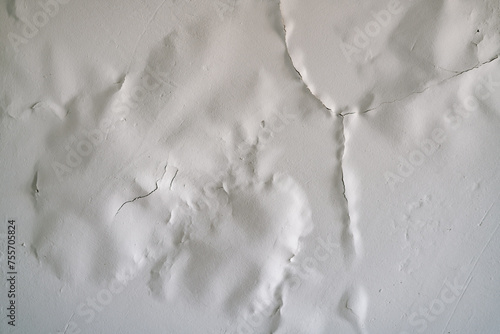 White paint swollen from moisture on the ceiling close-up