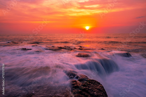 Enchanting atmosphere of the sea surf at sunset  waves spread over a rocky shore with a blur effect obtained using a long exposure