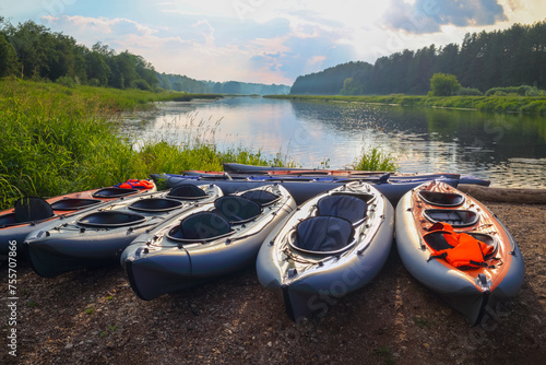 Inflatable boats with life-jackets are near beautiful river at sunny day photo