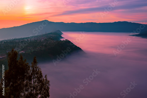 Magical view of a mountain valley filled with clouds at sunrise