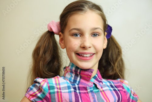 Beautiful girl in pink smiles in white room, close up portrait photo