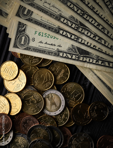 Money background with euro cents and one dollar bills over black wooden background