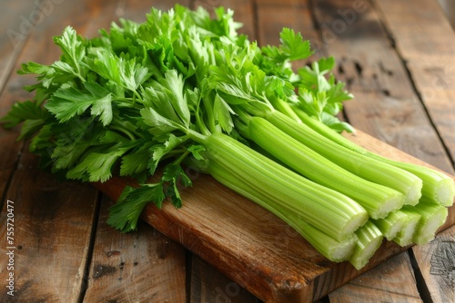 Fresh celery and parsley ingredients arranged on a wooden cutting board.