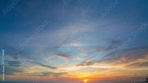 .Time lapse clouds float above the sea at sunset. The clouds, illuminated by the setting sun, .create a beautiful and serene atmosphere. .The beauty of the moment takes your breath away.. photo