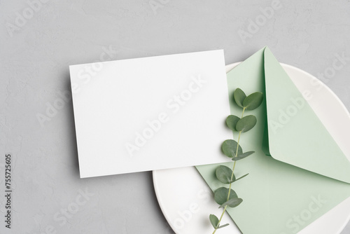 Blank wedding invitation card mockup with envelope and fresh eucalyptus twig, white card mock up with copy space