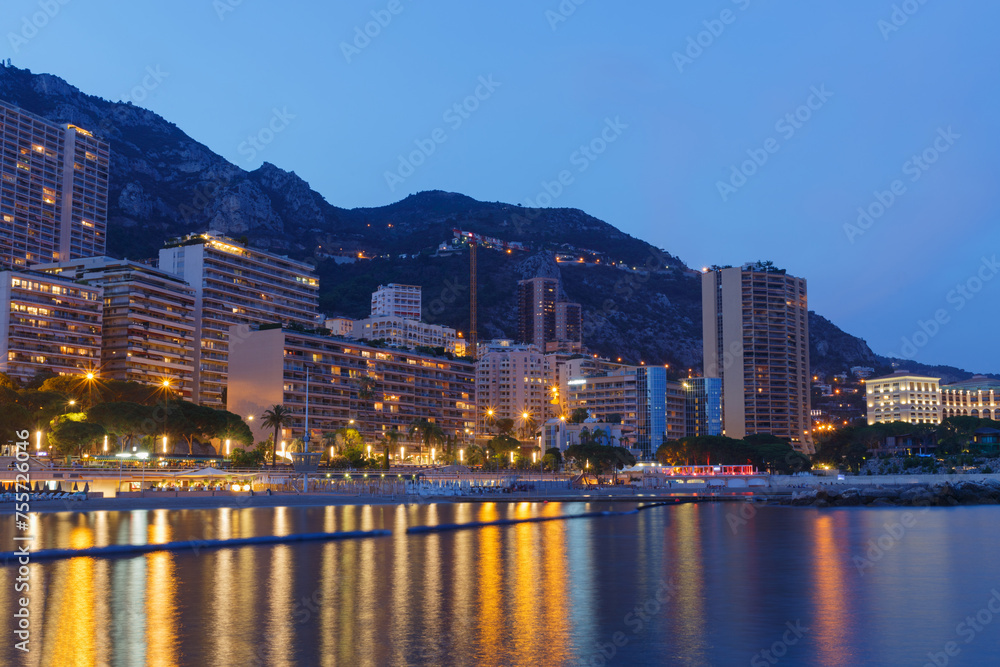 Sea beach and high-rise buildings densely populated area of Monaco, summer evening, long exposure