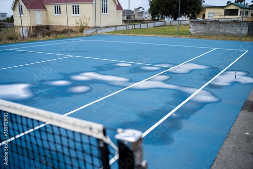 wet tennis court with puddles on a public sport court in australia © William