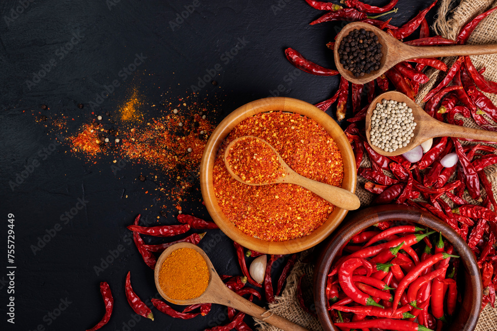 Fototapeta premium Dried chilies with chili powder, pepper, and red paprika in a wooden bowl Spicy seasoning Healthy food, top view
