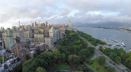 Cars ride by Henry Hudson Parkway near Riverside Park and 79th Street Boat Basin at summer evening. Aerial view
