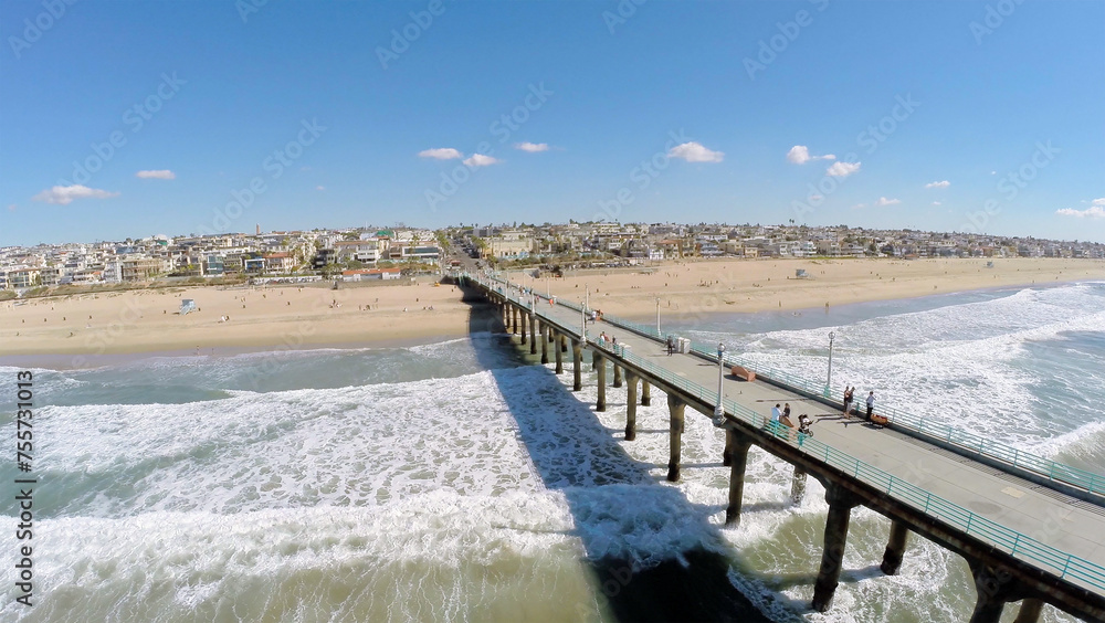  Cityscape with people walk by Manhattan Beach Pier at sunny day. Aerial view. Pier was built in 1920.