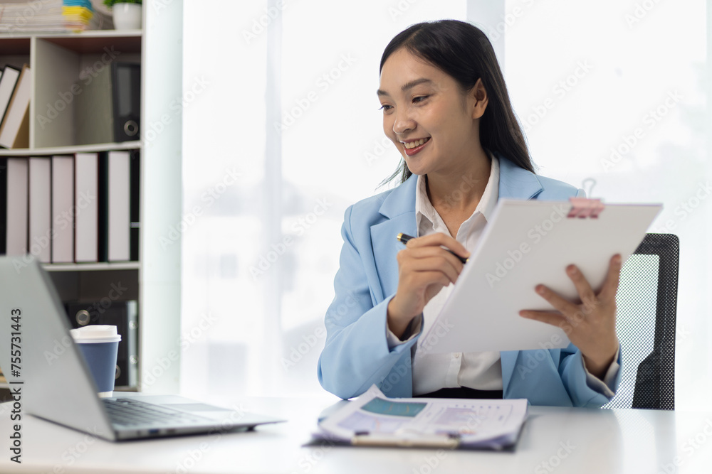 Asian businesswoman secretary doing paperwork on desk in office. Asian businesswoman secretary doing paperwork on desk in office.