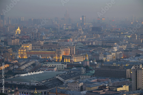 Illuminated buildings and roofs in fog at summer night in Moscow, Russia, Tverskoy area