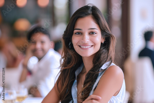 Indian businesswoman in blue formal shirt, arms crossed in meeting room