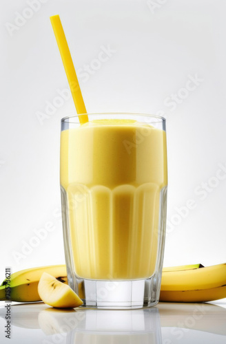 Banana smoothie yogurt in a transparent glass decorated with fresh fruit slices with straw
