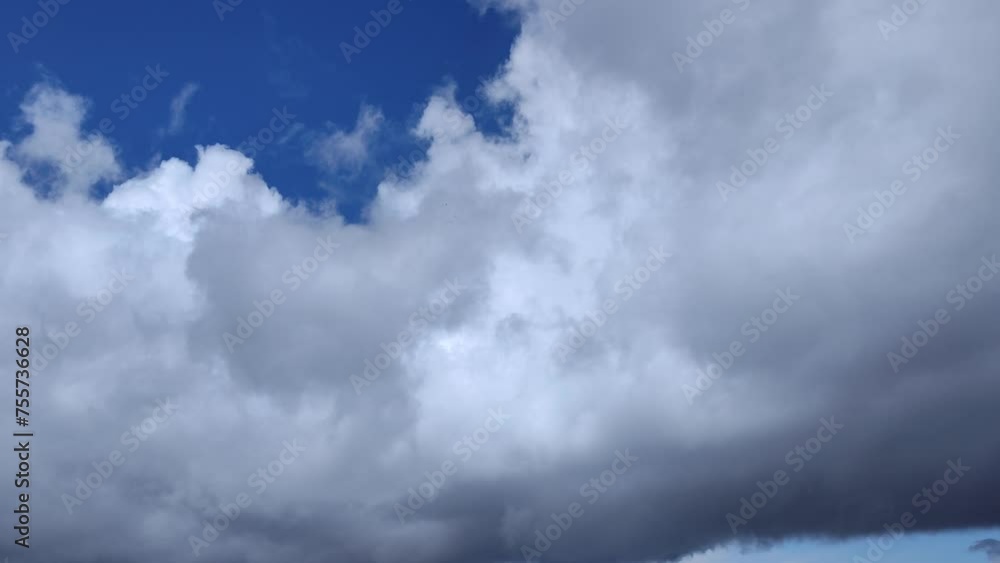 Huge cloud cluster accompanied by small gray clouds circulate in the sky at noon Huge cloud cluster accompanied by small gray clouds circulate in the sky at noon