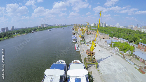  Several vessels and cranes in city river port at summer sunny day. Aerial view videoframe photo