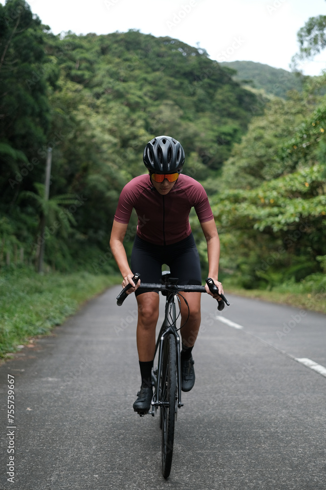 A young woman cyclist riding her gravel bike in the mountains. A young woman cyclist riding her gravel bike in the mountains.