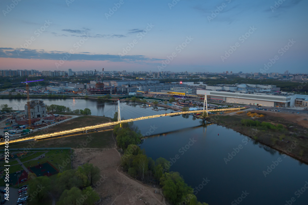 Fototapeta premium Suspended footbridge Pavshinskaya floodplain evening in Krasnogorsk, Russia