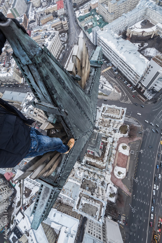 Legs of roofer on big star of Stalin skysraper in Red Gate Square in Moscow at winter photo