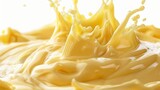 Creamy cheddar cheese sauce splashing in the air, isolated on a white background for food concept.