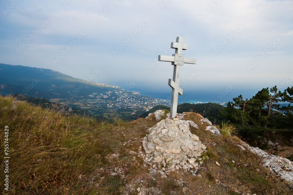 Cross on mountain, town and coast of sea far away at summer day