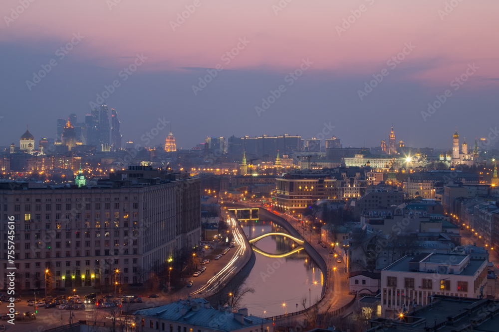 Drainage channel at Baltschug Island, sunset sky, bridge, roofs and high-rise buildings in Moscow, Russia